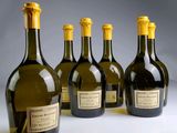 six bottles of wine are lined up in a row on a table