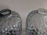 two glass vases sitting next to each other on a table