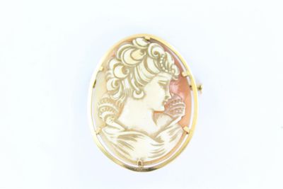 une image représentant une broche plaquée or avec le profil d'une femme