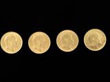four different types of gold coins in a row on a black background