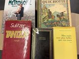 several books are sitting on a cardboard box on a table