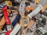 a pile of assorted watches and watches on a table