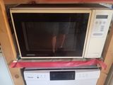 a microwave sitting on top of a dishwasher in a kitchen