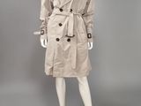 a mannequin wearing a beige trench coat and black top