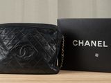 a black chanel bag sitting on top of a table next to a box