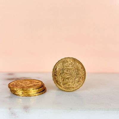 two gold coins sitting on top of a marble counter top