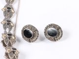 a necklace and earring set on a white surface