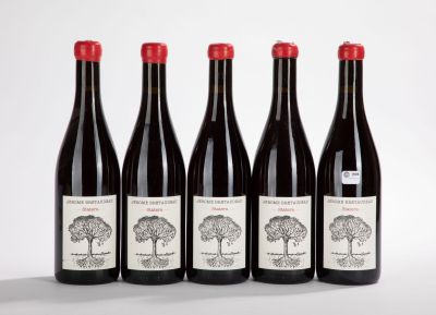 four bottles of wine are lined up on a white surface