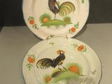 deux assiettes ornées de coqs, exposées