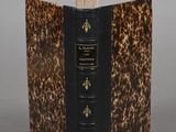 an old book sitting on top of a table covered in a leopard print cover