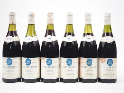 six bouteilles de vin alignées sur une surface blanche