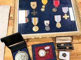 une photo montrant une collection de médailles et d'autres objets posés sur une table