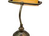 brass desk lamp with a yellow shade on a white background