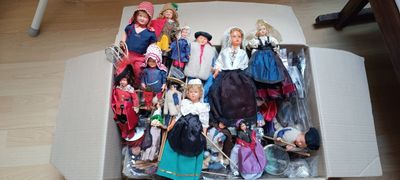 a box full of barbie dolls sitting on the floor