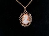 a close up of a necklace with a picture of a woman on it