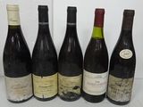 six bottles of wine are lined up on a table