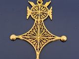 gros plan d'une croix en or sur une surface noire
