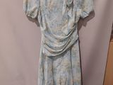 a dress hanging on a hanger in front of a white backdrop