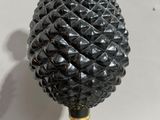 a black and gold pine cone lamp on a marble base