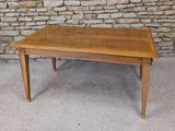 a wooden table that is sitting in front of a stone wall