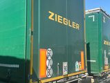 two green semi trucks parked next to each other