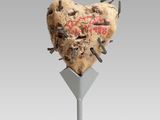 a heart shaped cookie on top of a stand