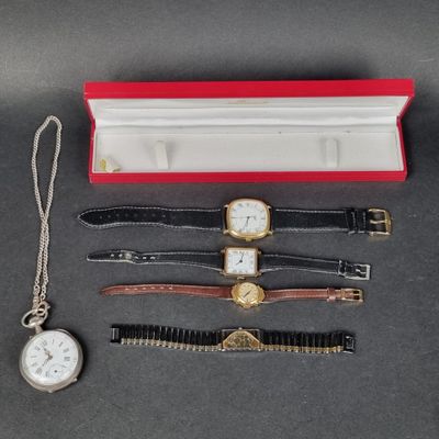 trois montres et une montre dans un coffret rouge posé sur une table