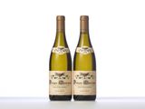 two bottles of white wine sitting on top of a table
