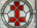 a stained glass window with a red cross in it