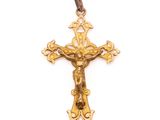 a close up of a gold cross with a jesus on it