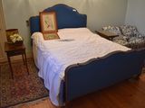 a bed with a blue headboard and a picture frame on it