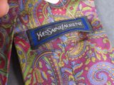 someone is holding a label on a tie that says mess saint laurent