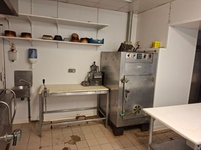 une image d'une cuisine avec une cuisinière et un réfrigérateur