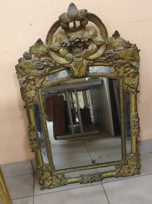 un miroir posé sur le sol à côté d'une chaise