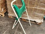 une chaise verte posée devant une pile de cartons