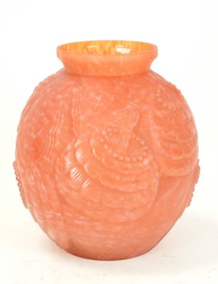 an orange vase that is sitting on a white surface