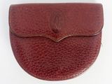 a close up of a brown leather purse on a white surface