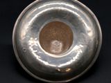 a silver vase with a silver lid on a black background