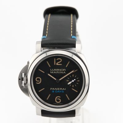 La montre est dotée d'un cadran noir et d'un bracelet en cuir noir.
