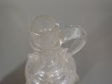 a clear glass vase with a clear handle on a table