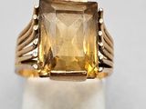 un gros plan d'une bague en or sertie d'une citrine facettée