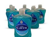 quatre flacons de savon pour les mains Carex sur fond blanc