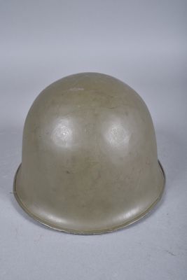 un vieux casque est posé sur une surface blanche