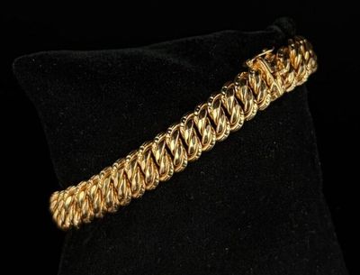 a close up of a gold bracelet on a black pillow