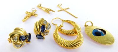 gold plated earrings and pendants with blue stones on a white surface