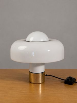 une lampe de table blanche posée sur une table en bois