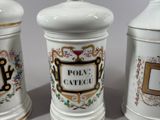 three white ceramic containers with decorative designs on them sitting on a table