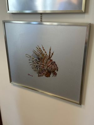 une image représentant un poisson accrochée au mur à côté d'un miroir
