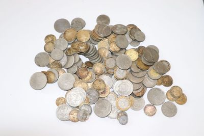 a pile of silver and gold coins on a white surface