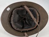 an old military helmet with a leather band and a metal buckle